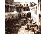 This early photo shows animals & vehicles accommodated in the courtyard of a khan (inn) or caravanserai (literally, `caravan-house`). Inns were at regular intervals of 13 1/2 miles along the roads.